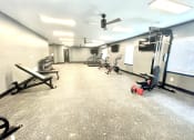 Thumbnail 4 of 14 - a large fitness room with exercise equipment and a ceiling fan at Murdock Gardens Apartments, Lafayette, IN 47904