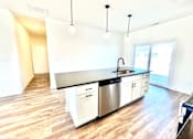 Thumbnail 24 of 37 - A kitchen with a black counter top and white cabinets.at Concord Crossing, Lafayette, IN  