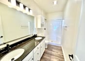 Thumbnail 22 of 37 - A bathroom with a sink, mirror, and wood flooring.at Concord Crossing, Indiana  