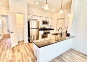 Thumbnail 10 of 37 - A kitchen with a stainless steel refrigerator and a black countertop.at Concord Crossing, Indiana  