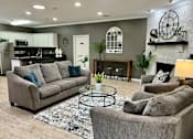 Thumbnail 7 of 19 - A living room with grey couches and a fireplace.
