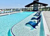 Thumbnail 15 of 49 - A pool with blue chairs and a black roof.