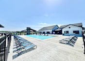Thumbnail 3 of 49 - A sunny day at the pool with lounge chairs and a clear blue sky.