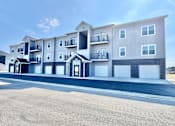 Thumbnail 40 of 57 - A modern apartment building with multiple balconies and garage doors.