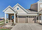 Thumbnail 3 of 20 - A house with a grey roof and a brown garage door.