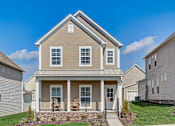 Thumbnail 2 of 20 - A house with a front porch and a small front yard.