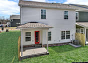 Thumbnail 18 of 20 - A white house with a red door and a small porch.