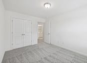 Thumbnail 16 of 27 - A room with a carpeted floor and white walls.