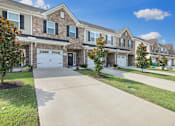 Thumbnail 1 of 27 - A row of houses with a driveway in the foreground.