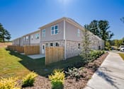 Thumbnail 13 of 25 - Side view of modern townhomes with landscaped walkway