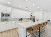 Thumbnail 17 of 25 - Luxury kitchen featuring white cabinets and breakfast bar