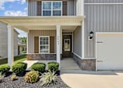 Thumbnail 18 of 44 - A house with a grey siding and a white garage door.