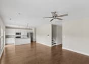 Thumbnail 23 of 44 - A spacious room with a ceiling fan and wooden flooring.