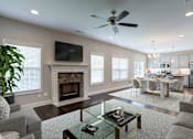 Thumbnail 4 of 19 - A modern living room with a fireplace and a television.