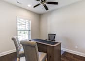 Thumbnail 16 of 19 - A room with a desk and chair and a ceiling fan.