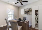 Thumbnail 6 of 19 - A room with a desk, chair, and a ceiling fan.