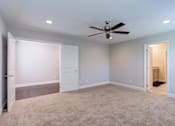 Thumbnail 15 of 19 - A room with a ceiling fan and carpeted floor.