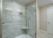 Thumbnail 17 of 19 - A bathroom with a walk-in shower and a white door.