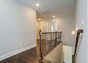 Thumbnail 7 of 19 - A staircase with a black railing and wooden steps.
