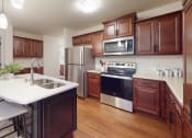 Thumbnail 22 of 28 - a kitchen with wooden cabinets and stainless steel appliances