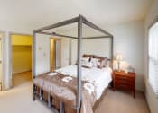 Thumbnail 15 of 28 - a bedroom with a bed and a nightstand