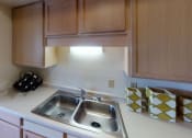 Thumbnail 14 of 28 - a kitchen with wooden cabinets and a stainless steel sink