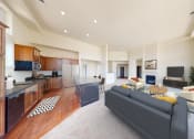 Thumbnail 42 of 64 - a living room with a couch and a kitchen with a table
