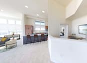 Thumbnail 3 of 15 - a kitchen and living room with a counter and a table with chairs