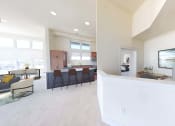 Thumbnail 43 of 64 - a kitchen and living room with a counter and a table with chairs