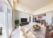 Thumbnail 36 of 64 - a living room with a couch and a table and a television
