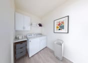 Thumbnail 29 of 64 - a small kitchen with white appliances and a painting on the wall