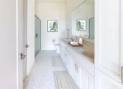 Thumbnail 26 of 64 - a bathroom with a sink and a toilet and a mirror