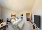 Thumbnail 11 of 38 - A bedroom with a bed, desk, and chair.