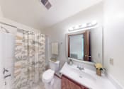Thumbnail 43 of 65 - A bathroom with a toilet, sink, and shower curtain.