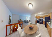 Thumbnail 48 of 53 - A modern kitchen with a dining table set for two.