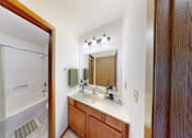 Thumbnail 44 of 53 - A bathroom with a sink, mirror, and shower.
