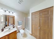 Thumbnail 4 of 26 - A bathroom with a toilet, sink, mirrors and a wooden door.