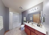 Thumbnail 6 of 42 - A bathroom with a toilet, sink, and mirror.