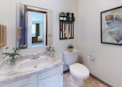 Thumbnail 9 of 21 - A bathroom with a marble countertop and a toilet.