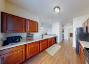 Thumbnail 3 of 59 - A kitchen with wooden cabinets and a black fridge.
