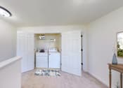 Thumbnail 6 of 59 - A white laundry room with a washer and dryer.