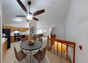 Thumbnail 6 of 12 - A kitchen with a table and chairs in the middle of the room.