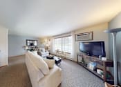 Thumbnail 2 of 50 - A living room with a couch, a television, and a dining table.