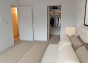 Thumbnail 29 of 32 - a bedroom with a bed and a closet and a lamp