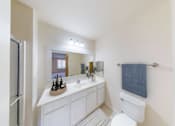 Thumbnail 22 of 30 - A white bathroom with a towel hanging on the wall.