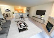 Thumbnail 6 of 21 - a living room with couches and chairs and a fireplace
