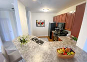 Thumbnail 9 of 26 - a kitchen with a large island with a bowl of fruit on it