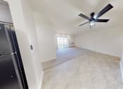 Thumbnail 21 of 32 - a living room with a ceiling fan and a large empty room