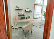 Thumbnail 3 of 28 - a desk with a laptop and a chair in a room with a window