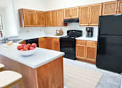 Thumbnail 7 of 28 - a kitchen with black appliances and wooden cabinets